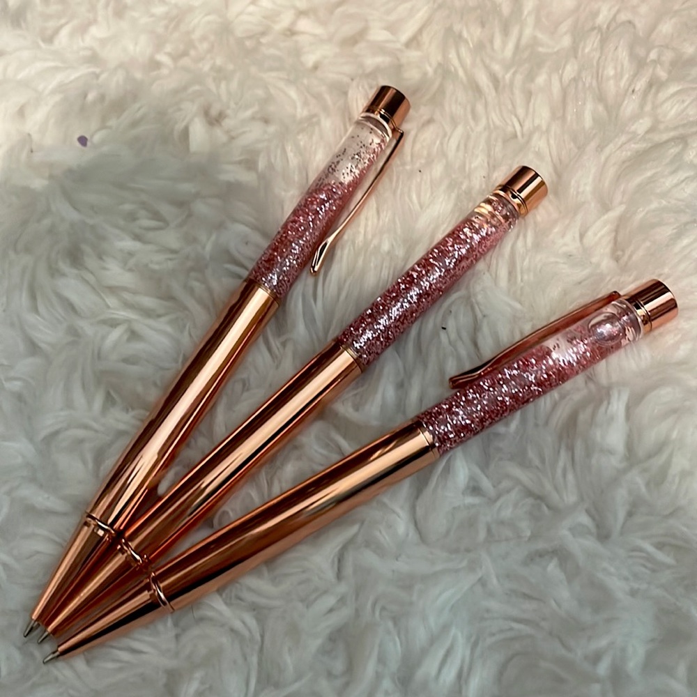 Three rose gold pens with pink glitter tops